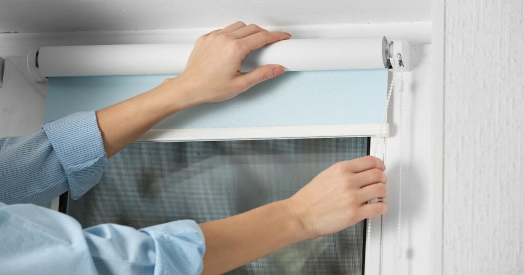 a person installing roller blinds