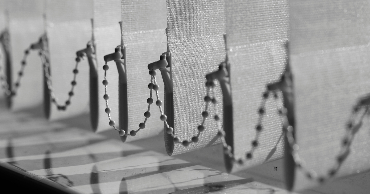 a close-up photo of grey vertical blinds